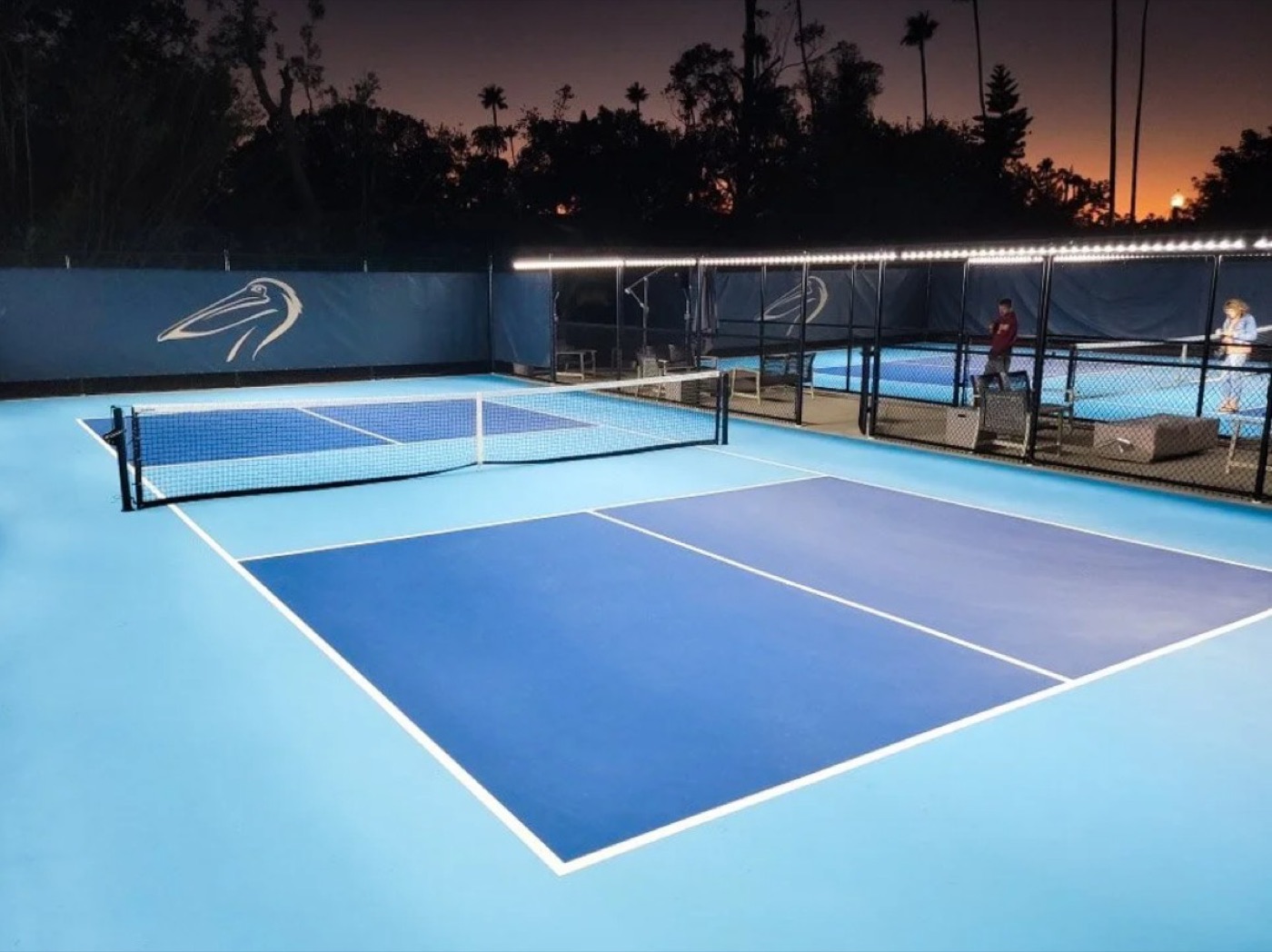 Players on floodlit courts at Pelican Golf Club, Belleair, Florida, at dusk