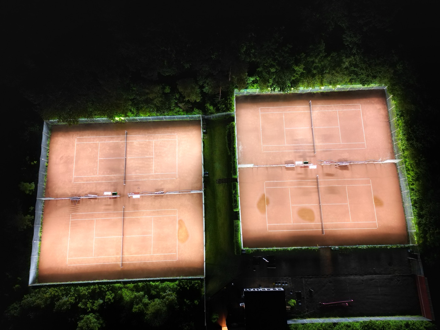 Aerial view of two floodlit clay courts at Ry Tennis Club, Denmark